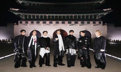 Ketujuh anggota BTS berpose bersama di depan gerbang istana bersejarah di Seoul pada malam hari