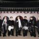 Ketujuh anggota BTS berpose bersama di depan gerbang istana bersejarah di Seoul pada malam hari