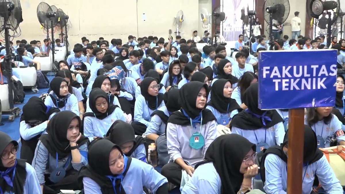 Mahasiswa baru Fakultas Teknik duduk bersila di dalam ruangan bersama papan penanda ber tuliskan Fakultas Teknik