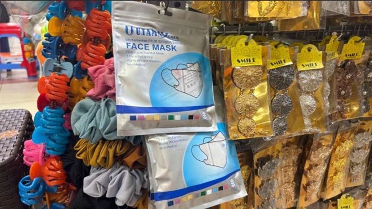 Kemasan masker wajah yang digantung di toko bersama jepitan rambut dan aksesori lainnya