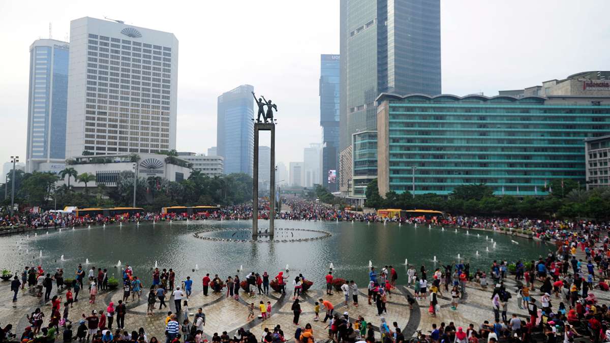 Suasana Bundaran HI di Jakarta yang dipadati warga dengan latar belakang gedung-gedung bertingkat