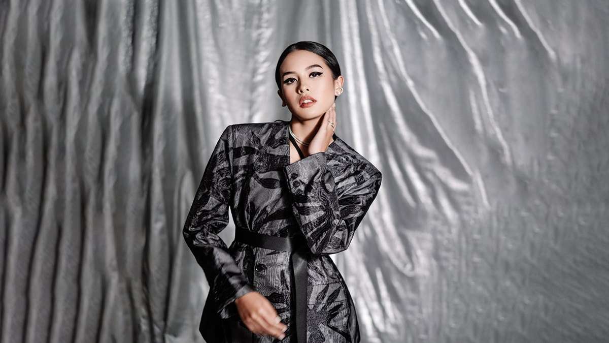 Maudy Ayunda Ajak Generasi Muda Ambil Peran Nyata sebagai Agen Perubahan Bangsa 50 Maudy Ayunda mengenakan blazer bermotif abu-abu dengan latar belakang tirai perak berkilau