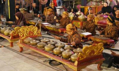 Anak-anak mengenakan busana tradisional Jawa sedang memainkan seperangkat alat musik gamelan