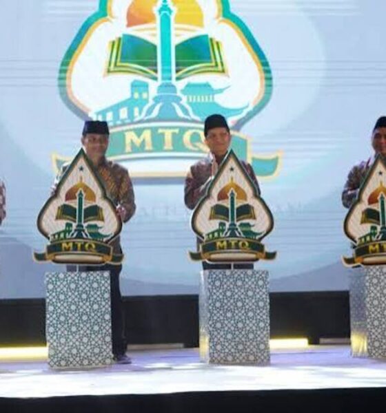 Lima orang pejabat berdiri di atas panggung di depan podium bermotif untuk meresmikan pembukaan MTQ
